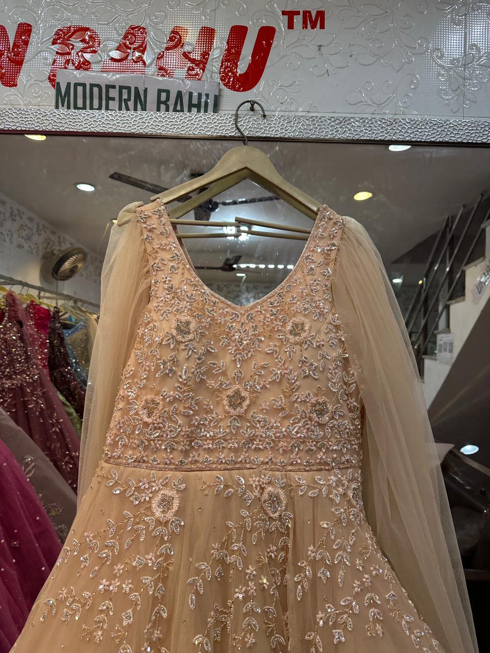 Elegant Peach Net Gown with Floral Sequin Embroidery & Floor-Length Cape Sleeves – Engagement & Party Wear