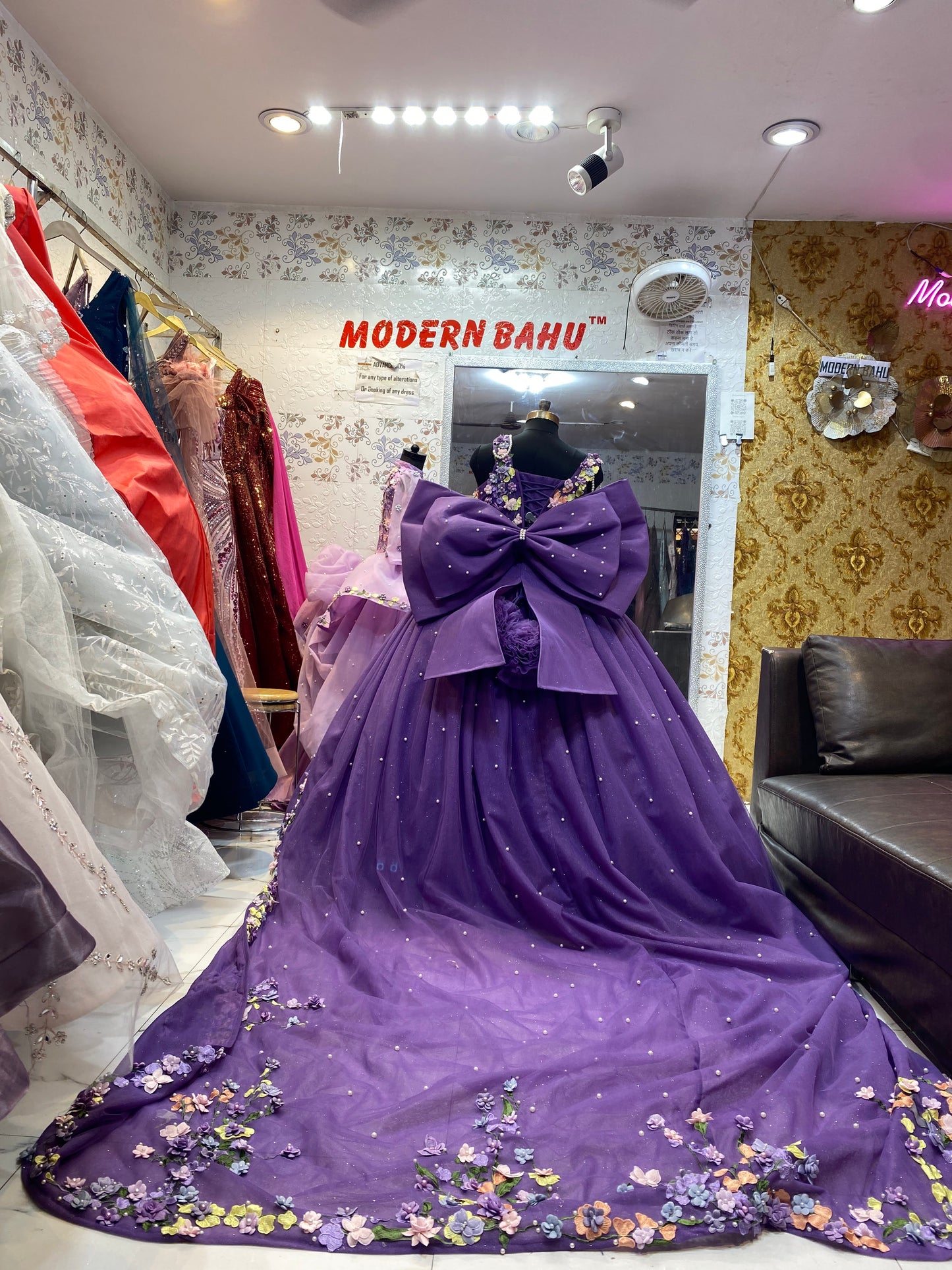 Purple dress with floral details on a mannequin in a store setting.